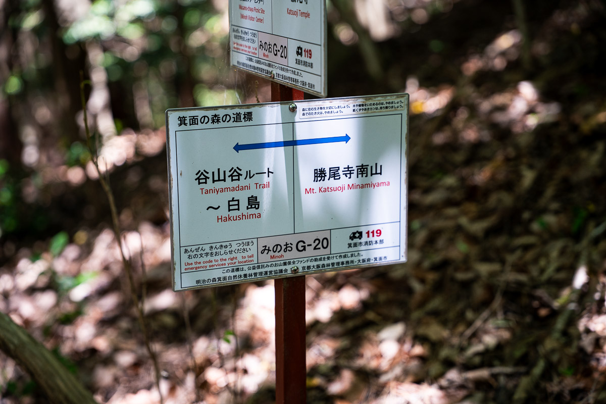 G-20看板に縦書きされた「勝尾寺南山」への案内表示